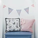 Two cushions sitting on a chair with bunting above